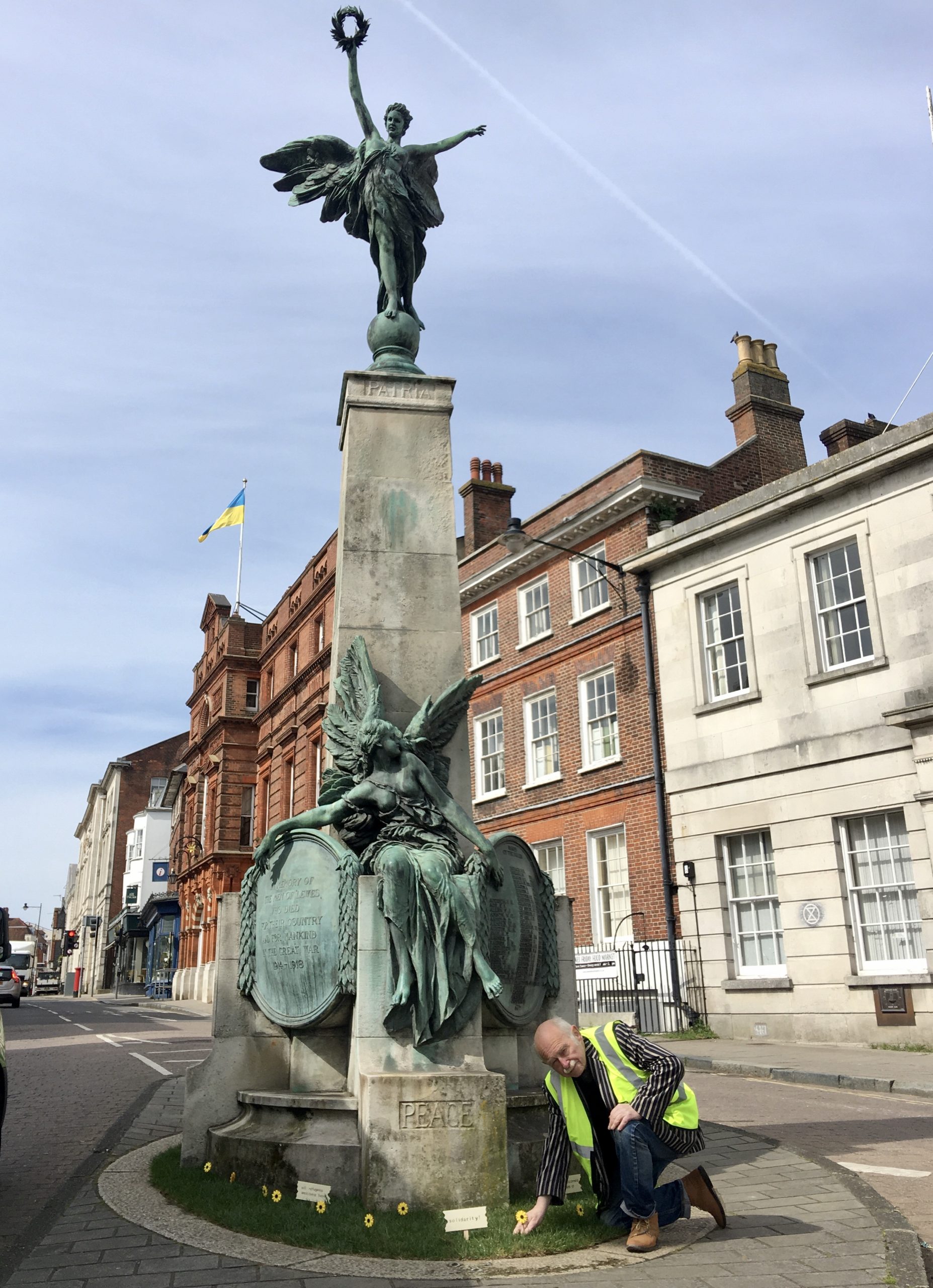 Cllr Stephen Catlin by the Lewes War Memorial planting wooden sunflowers